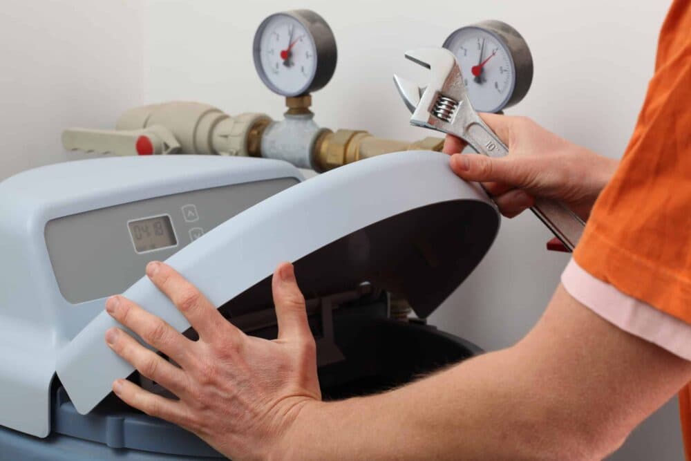 Plumber repairing water softener