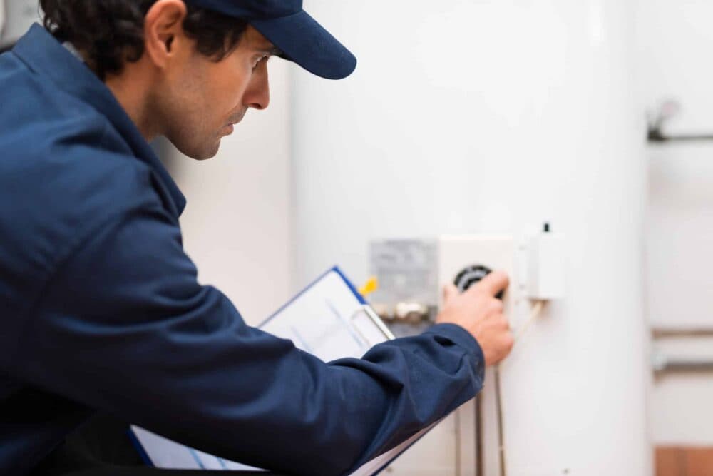 Technician adjusting regulator on water heater.